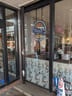Tully's Coffee: Glass storefront with a large circular Tully's Coffee logo, patterned lower window film, and a no bicycle parking sign outside the entrance.