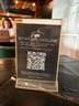 Table sign in a clear holder promoting Station House membership with a QR code and details about complimentary wifi hours with purchase.